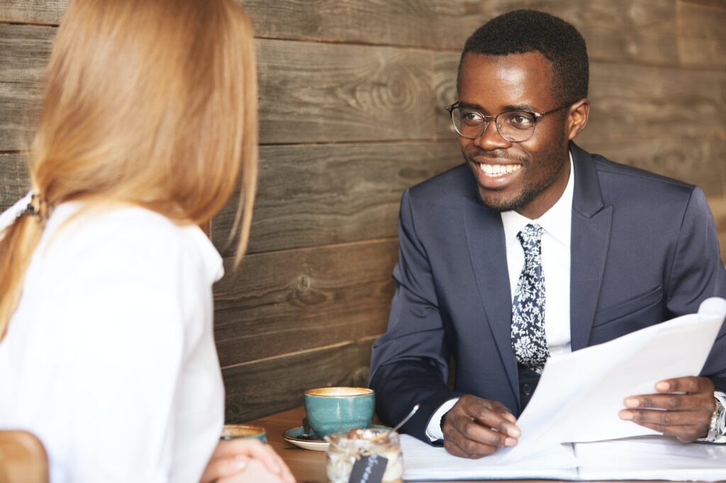 Successful negotiations. Smiling cheerful African American entrepreneur wearing glasses and formal s